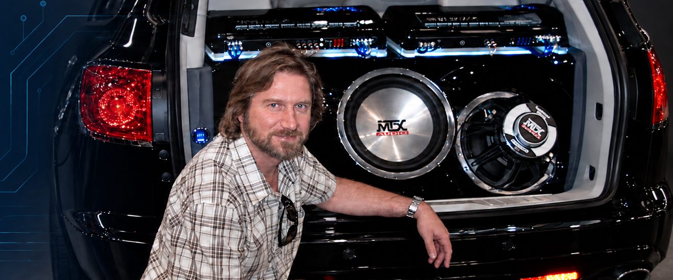 Alex Lapayev beside a car audio installation
